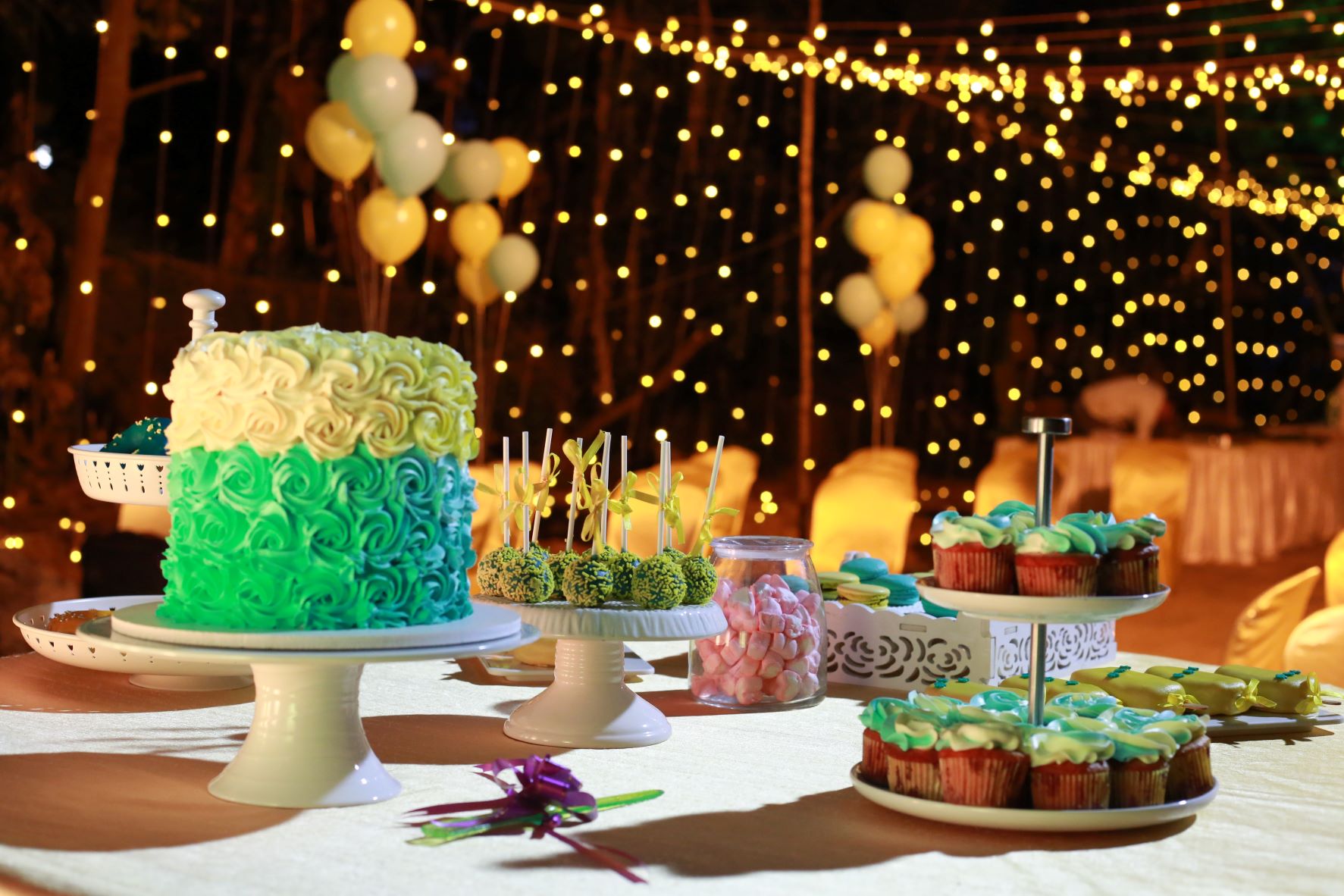A dessert table with a cake and cupcakes